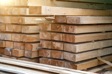 Wooden planks at lumber warehouse. Piles of wooden boards at store outdoors. Wood timber stack of...