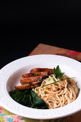 Asian food concept homemade organic Alkaline noodles with duck roasted on wooden board with black background with copy space