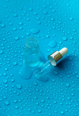 Bottle of cosmetics and drops of liquid, moisturizing. Hyaluronic acid. Selective focus.