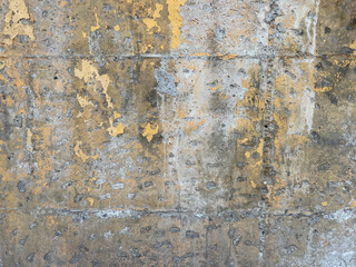 Old weathered plastered concrete wall texture, old dirty flaky concrete wall with damaged yellow painting, grunge texture