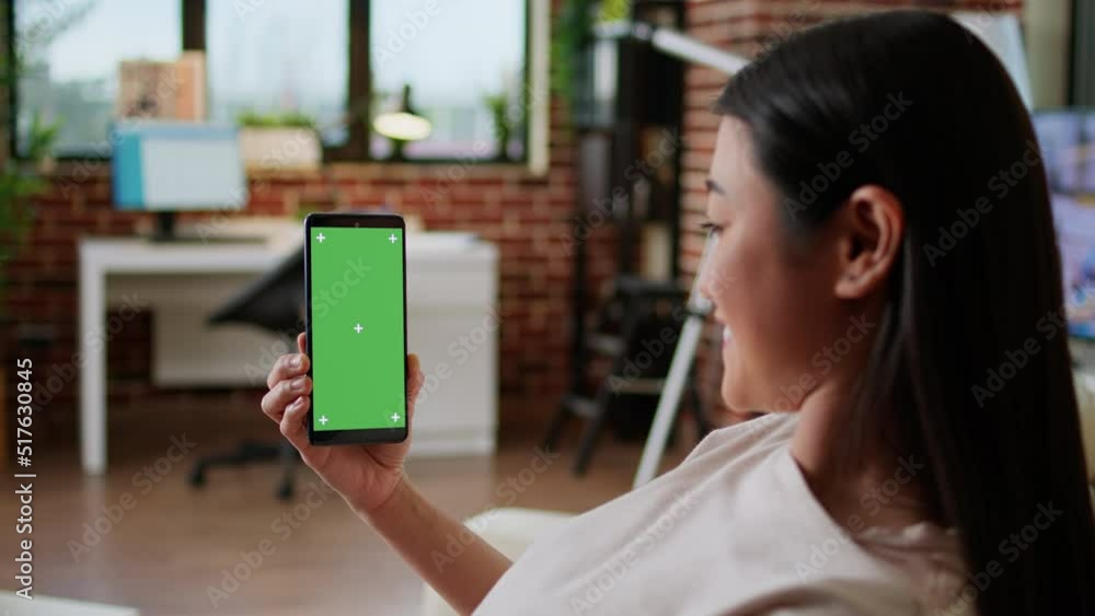 Poster cheerful person sitting on couch with mobile cellphone having chroma key mockup display background. 