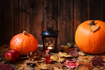 autumn composition with pumpkins and a lantern on fallen leaves, halloween pumpkins