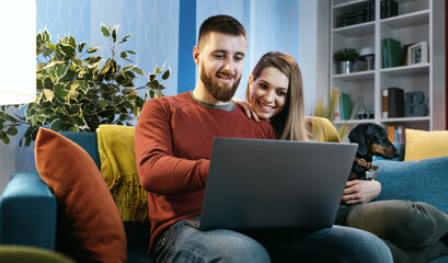 Young couple connecting with a laptop at home