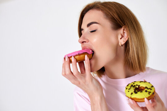 beautiful blonde woman with donuts on white background.