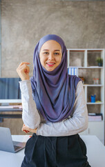 Young muslim woman working in business office, wearing Hijab works as start up SMEs project. Looking Camera.