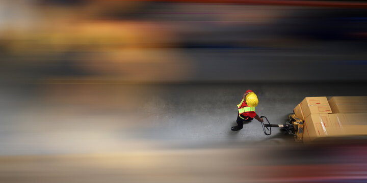 Top-Down View: Worker Moves Cardboard Boxes using Manual Pallet Truck, Warehouse. People Work in Product Distribution Logistics Center