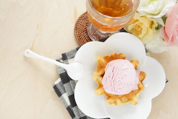 Strawberry ice-cream on Belgium waffle and iced teafor dessert image