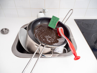 Washing dishes while cleaning the house.