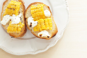 Boiled Japanese sweet corn and cream cheese on French bread toasted for summer healthy breakfast