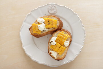 Boiled Japanese sweet corn and cream cheese on French bread toasted for summer healthy breakfast