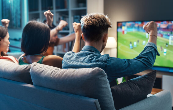 Group of friends watching a football match on TV