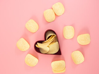 Chips in a box on a pink background.