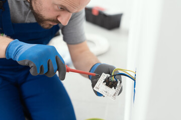 Professional electrician installing a wall socket