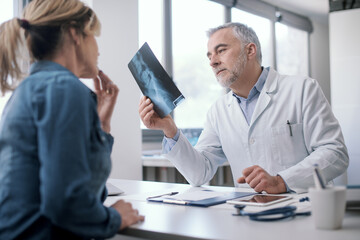 Naklejka na ściany i meble Doctor checking a patient's radiography