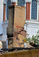 The chimney of a destroyed historic building on a summer day