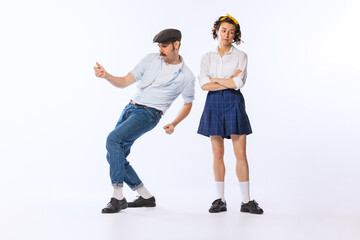 Portrait of young stylish woman and dancing cheerful man posing isolated over white studio...