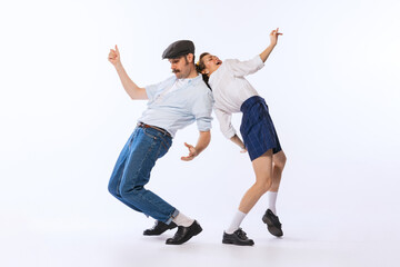 Portrait of young beautiful couple, man and woman, dancing retro dance isolated over white studio...