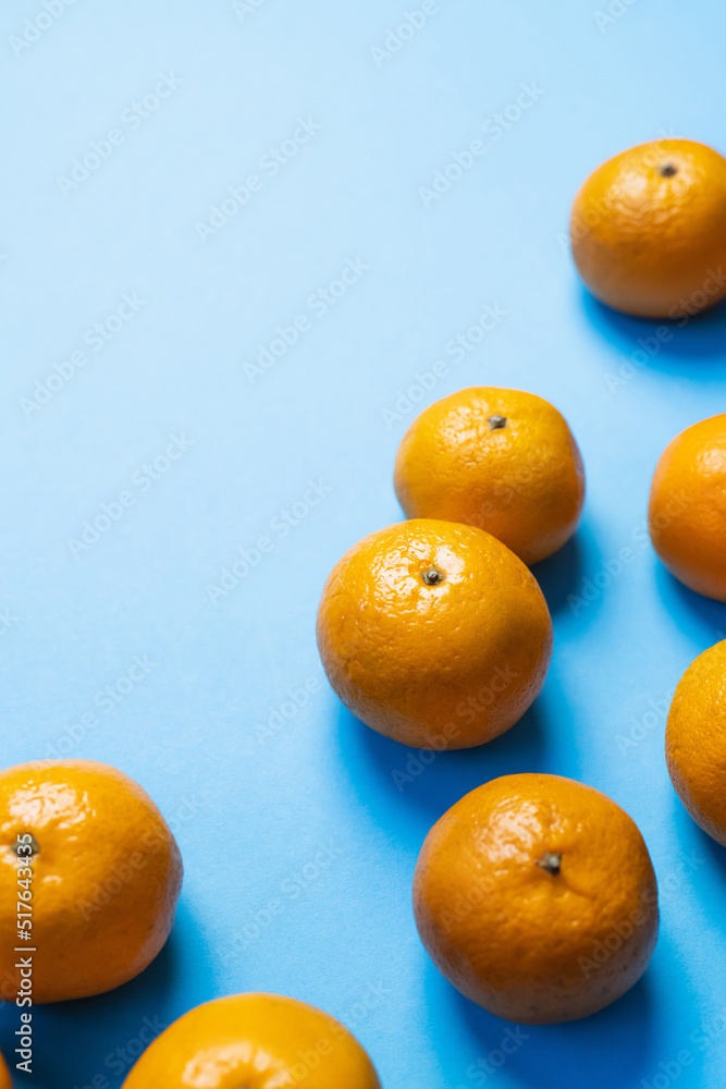 Canvas Prints high angle view of natural tangerines with shadow on blue background.