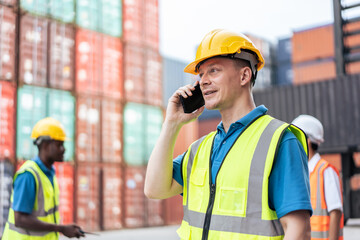 Handsome Caucasian businessman use phone to work in container terminal