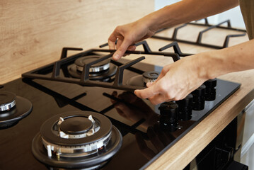 Hands installing gas stove grill after cleaning, Kitchen appliance maintenance