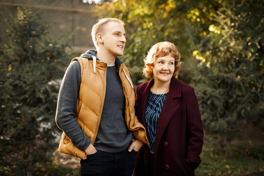 Mom and son look into the distance in the forest among the trees outdoors. High quality photo