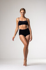 Fototapeta premium Young sexy girl in black lingerie on white background