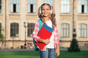 Happy teenage girl back to school outdoors, music