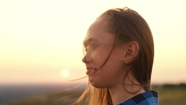 girl with long hair wind. smile child girl sunset. person breathes fresh air. eco. girl dream. teenager pray dawn. beautiful face long-haired girl wind close-up. clean air concept. breath nature park