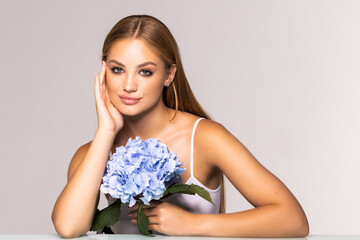 Beauty face of the young beautiful woman with flower on white background