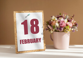 february 18. 18th day of month, calendar date.Bouquet of dead wood in pink mug on desktop.Cork...