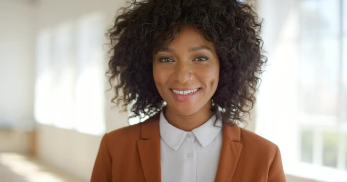 Businesswoman woman smiling in office. African lady with cute dimples puts a smile on her face standing in the workplace. Intern ready to help grow the company by adding value in the corporate space