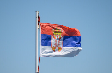 The flag of Serbia. The flag of Serbia on a blue background - the sky.