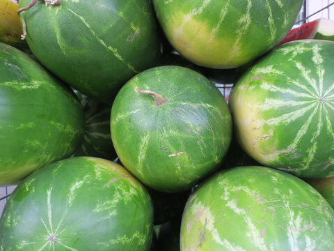 collection of watermelons in front of a grocery store