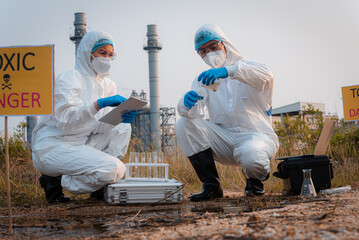 Ecologist taking samples of water with test tube from city river to determine level of contamination and pollution, Research conserve water and environment.