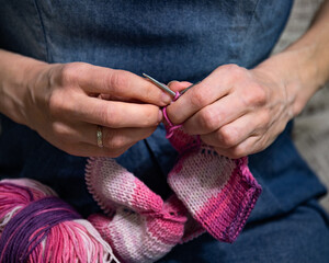 Woman's hands knits on circular knitting needles, close up.