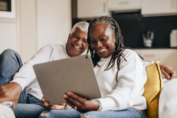 Happy senior couple having a video call at home