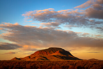 Fototapeta na wymiar An image of beautiful sunset, clouds, sky, and red rock Mt Robinson in Karijini national park, Western Australia