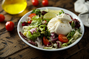 Healthy green salad with tomato and burrata cheese