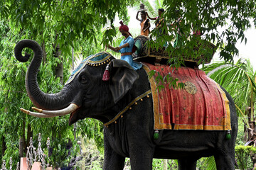 KOLHAPUR, INDIA - JULY 17, 2022:
Statue of a decorated elephant with the chariot, aIndian man and...