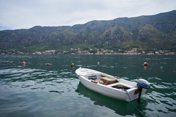 Naklejka na ściany i meble White fishing boat with an engine on a background of mountains