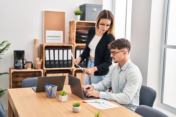 Young man and woman business workers using laptop working at office