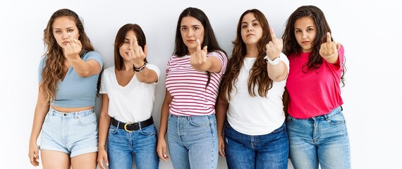 Group of women wearing casual clothes standing over isolated background showing middle finger,...