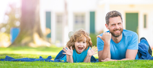 Banner of father and son in summer park outdoor. happy father with kid relax together on green park grass, copy space, family day