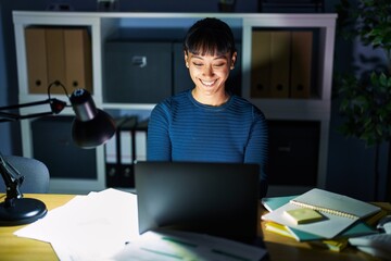Young beautiful woman working at the office at night with a happy and cool smile on face. lucky person.