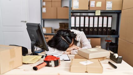 Young latin woman ecommerce business worker tired sleeping at office
