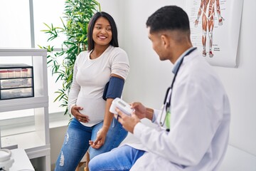 Young latin couple doctor and patient using tensiometer at clinic