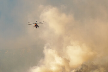 Fototapeta na wymiar Helicopter against the big fire at Loutraki in Greece.