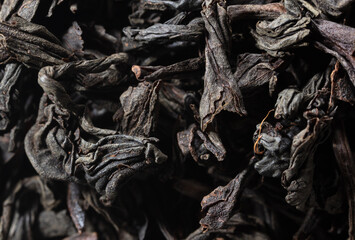 Dried black tea leaves as background.