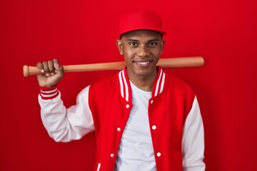 Young hispanic man playing baseball holding bat with a happy and cool smile on face. lucky person.