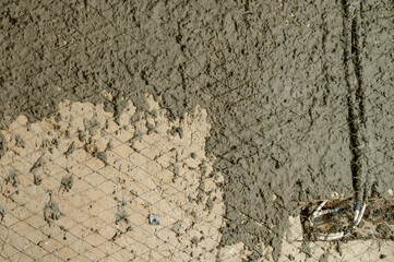 The master throws a solution of liquid concrete on the wall, the first layer of plaster on the wall.